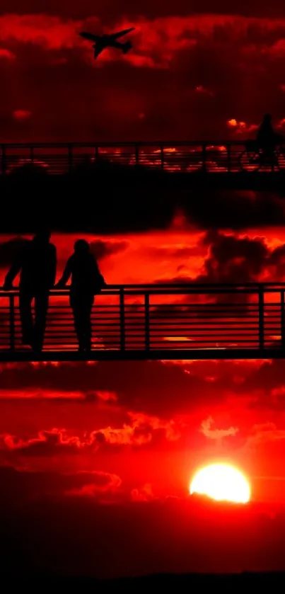 Silhouette art of people at sunset with vibrant red sky.