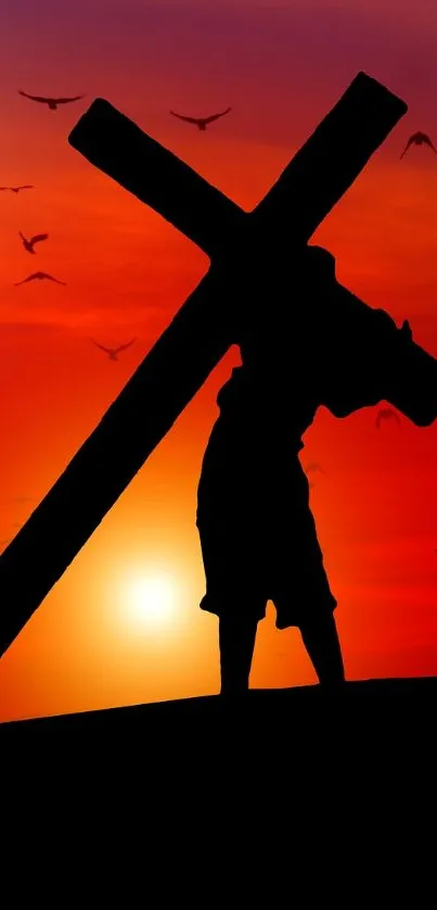 Silhouette carrying a cross against a vivid sunset backdrop with birds flying.