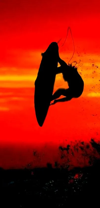 Silhouette of a surfer against a vibrant red sunset sky.