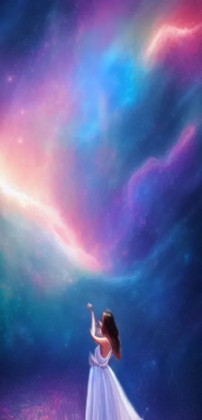 A woman in white reaches for the vibrant, colorful galaxy night sky.