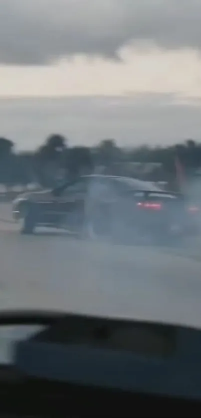 Car drifting through smoke on a road.