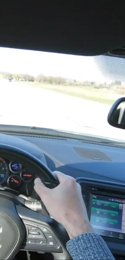 Dashboard view of a car driving on a sunny highway.