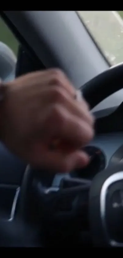 Hand on steering wheel in car interior with a focus on luxury design.