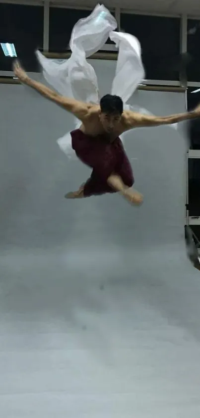 Dancer in dynamic pose mid-air on a studio backdrop.