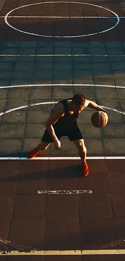 A basketball player dribbles on a sunlit urban court.