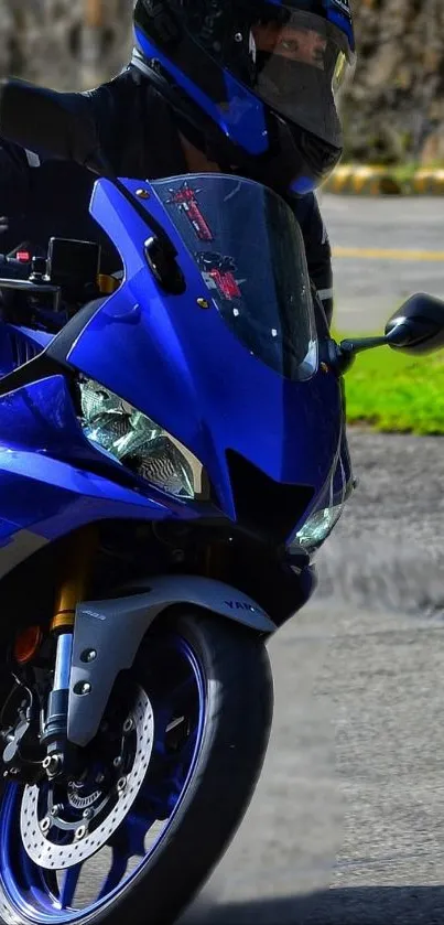 Blue motorcycle with helmeted rider on road.