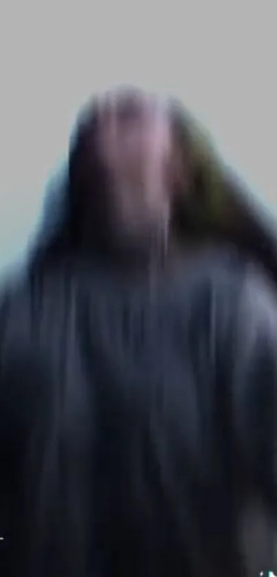 Dynamic blurred figure against gray background, creating motion.