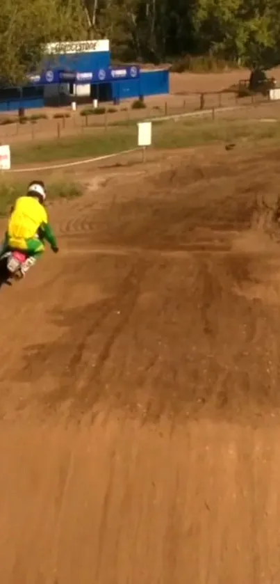 BMX racer speeding on a dirt track with vibrant gear.