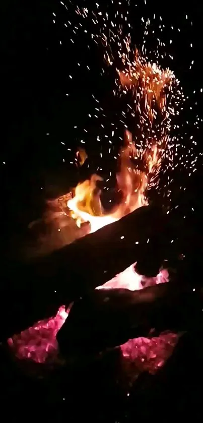 Vibrant campfire sparks with wood logs in a dark setting.