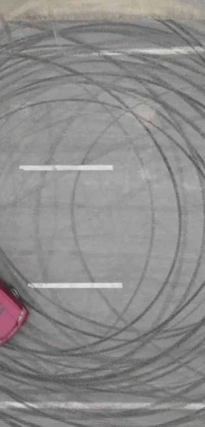 Red car drifting on a gray asphalt track with tire skid marks.