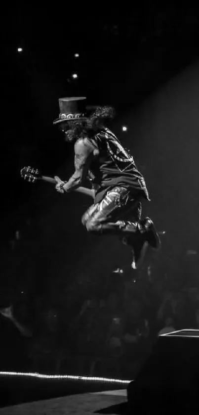 Black and white image of a guitarist jumping on stage during a concert.