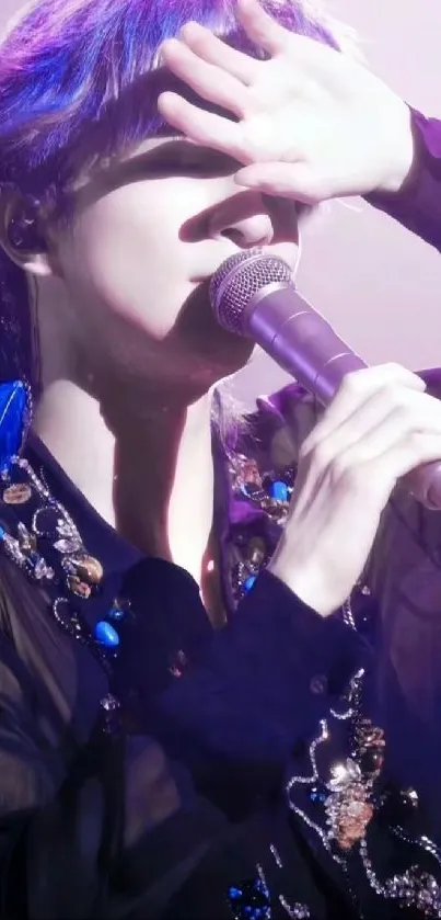 Performer on stage with microphone in purple lighting.