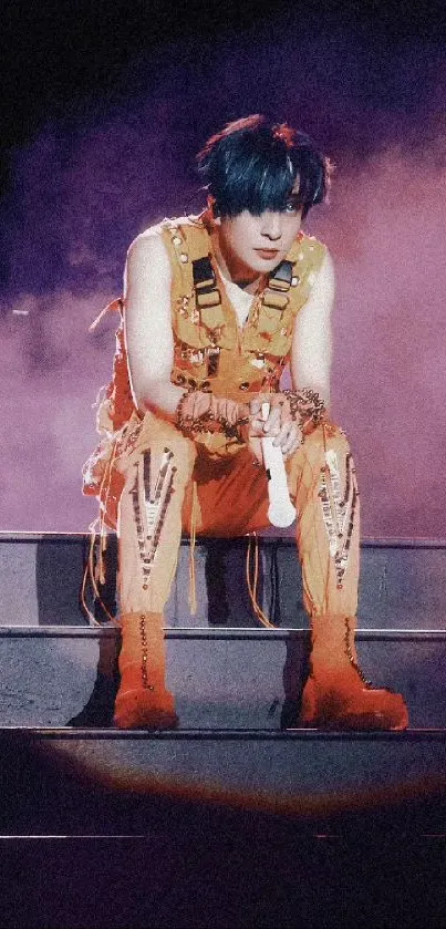 Concert performer in orange outfit on stage.