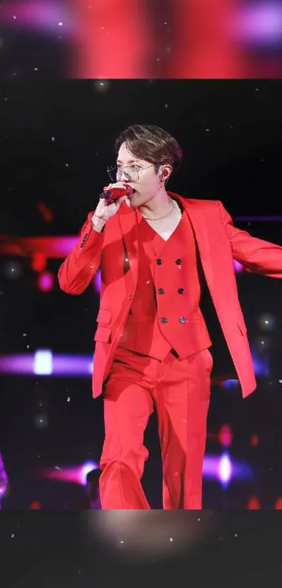 Performer in a red suit on stage during a lively concert.