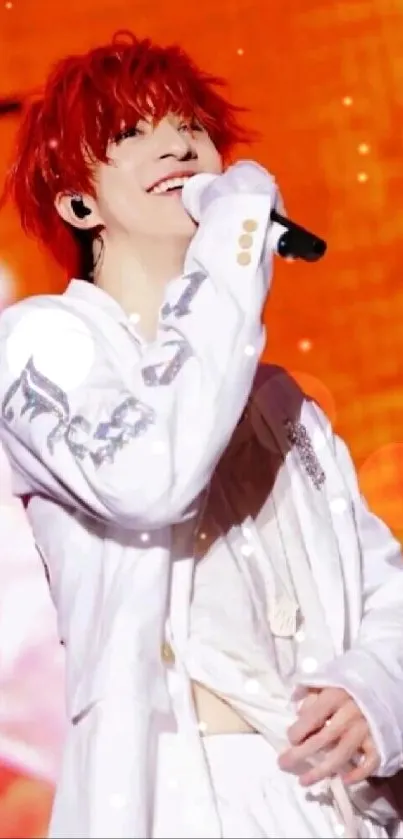 Performer in white outfit against bright orange background on stage.