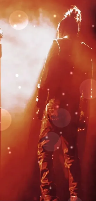 Silhouette of a performer on stage with orange lighting.