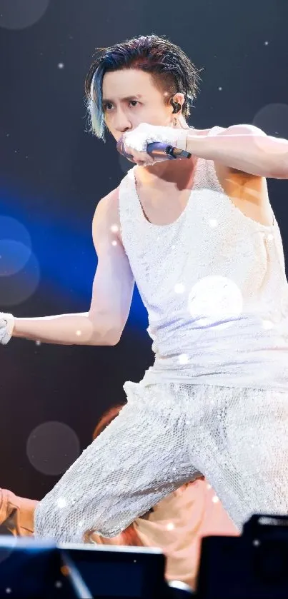 Dynamic performer in glittering outfit on stage with vibrant lighting backdrop.