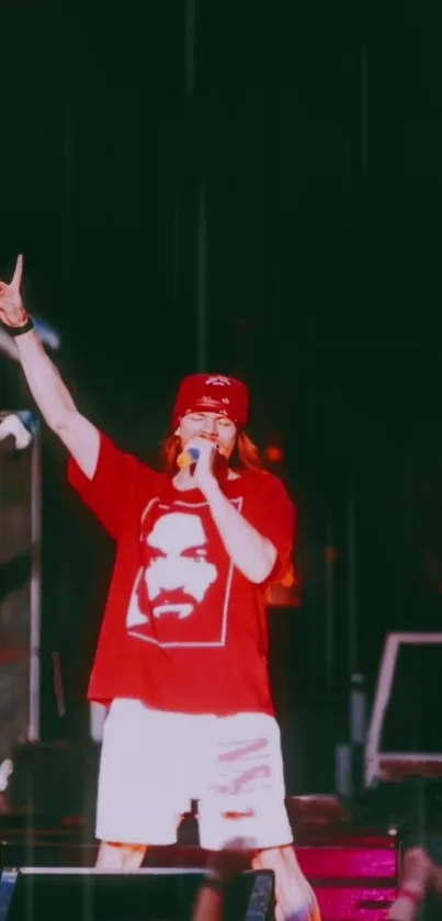 Performer in red shirt on stage during concert.