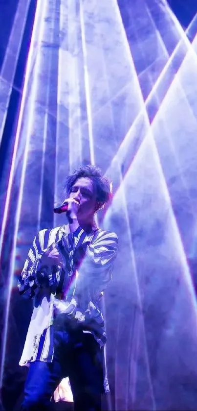 Singer on stage with vibrant blue and purple concert lighting.