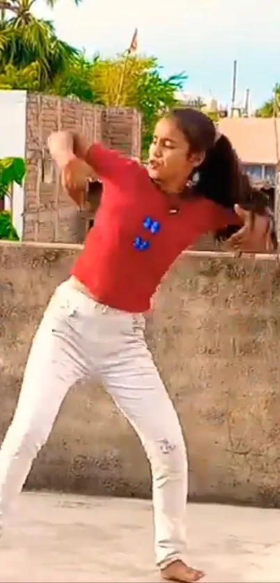 Young girl dancing energetically outdoors on a rooftop.