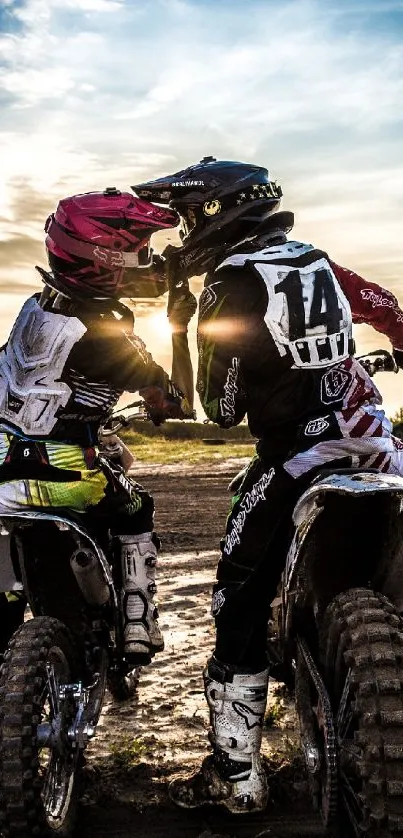 Two dirt bike riders at sunset on a track.