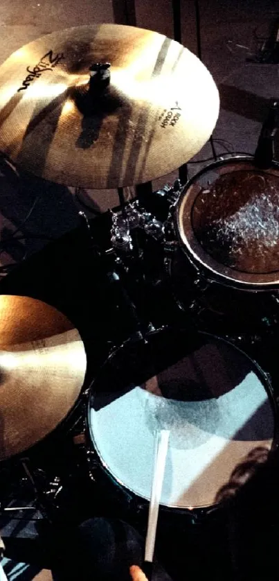 Overhead view of a drum set on stage with dynamic lighting.