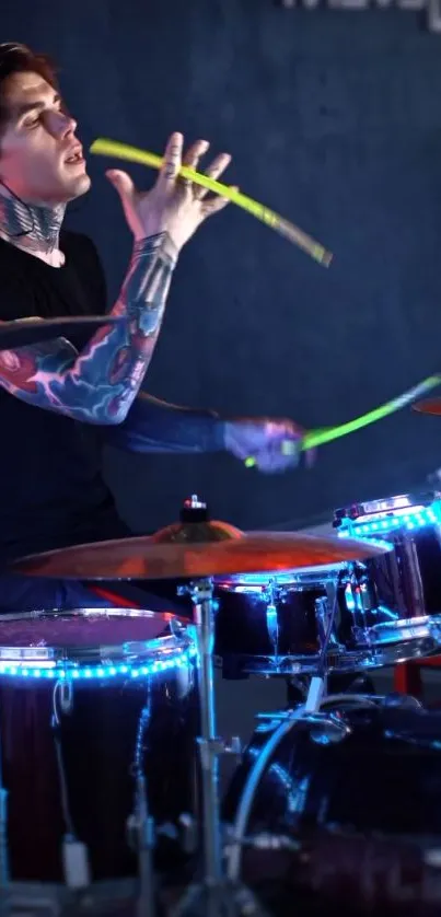 A tattooed drummer plays neon-lit drums energetically.