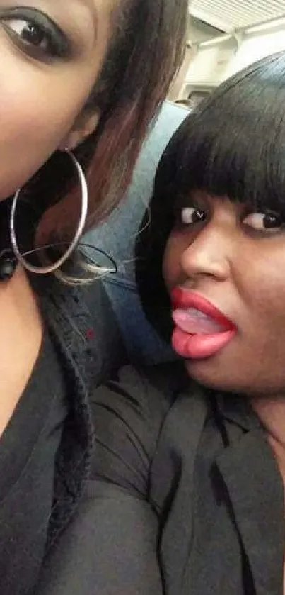 Two friends taking a playful selfie on a train.