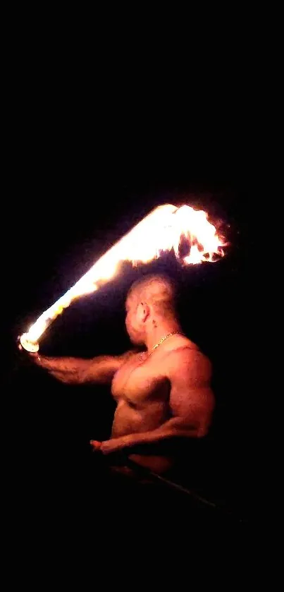 Fire performer with flame in dark background wallpaper.