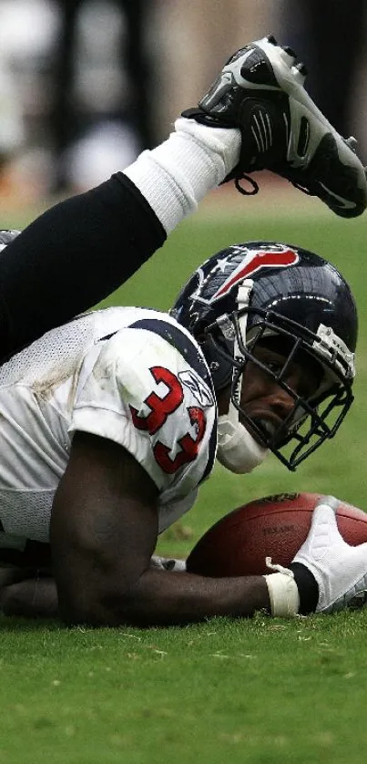 Football player in action during a game, holding the ball on the field.