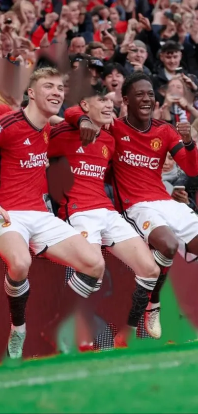 Football players celebrating in vibrant red kits on the field.