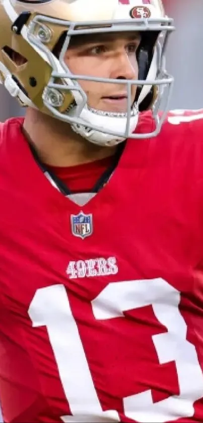 Football player in striking red uniform with gold helmet on the field.