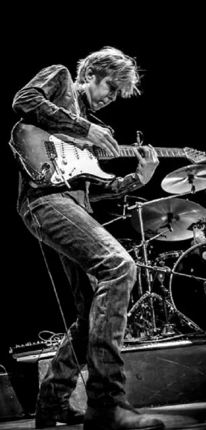 Black and white image of dynamic guitarist performing on stage.