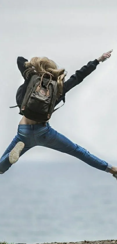 Traveler jumps energetically by the ocean with a dynamic blue background.