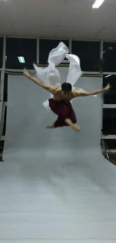 Martial artist leaps dynamically in studio.