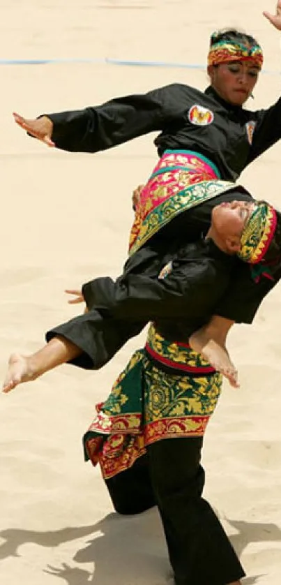 Martial artists in vibrant traditional attire showcasing dynamic movements on a sandy beach.