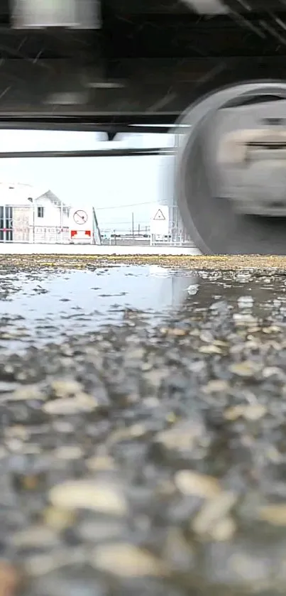 Car speeds over wet road in urban scene with motion blur effect.