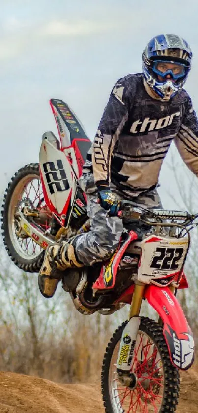 Motocross rider performing a thrilling stunt in a dynamic outdoor setting.