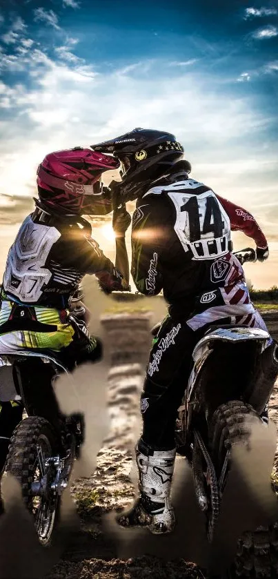 Motocross riders racing at sunset with a vibrant sky in the background.