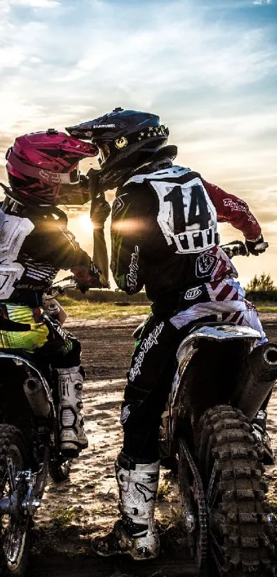 Motocross riders riding at sunset with a scenic golden sky.