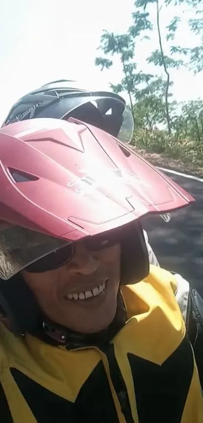 Two motorcyclists wearing helmets on a sunny road with trees.