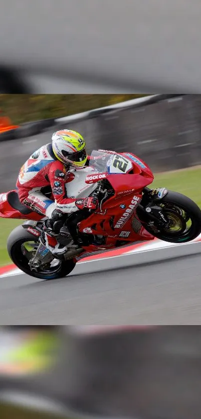 A professional motorcycle racer on a red bike in motion on a track.