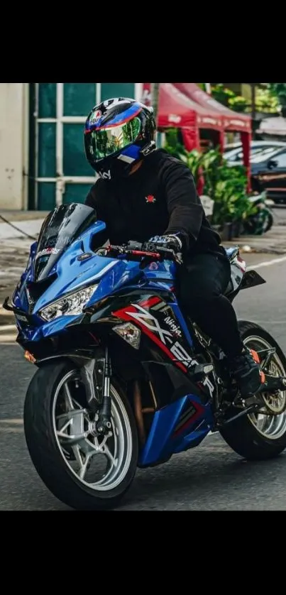 Blue sports motorcycle cruising down a city street with a helmeted rider.