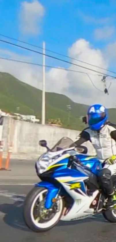 Blue motorcycle on road with scenic backdrop.