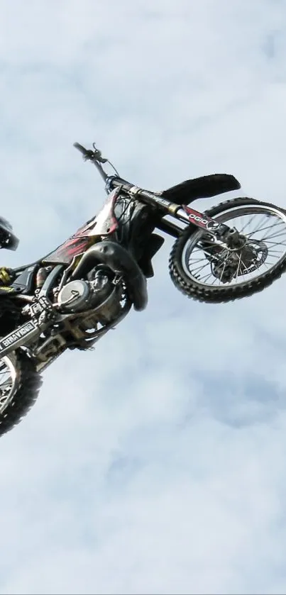 Motorcycle stunt in the sky with rider mid-air.