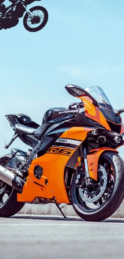 Orange motorcycle with a clear sky backdrop.