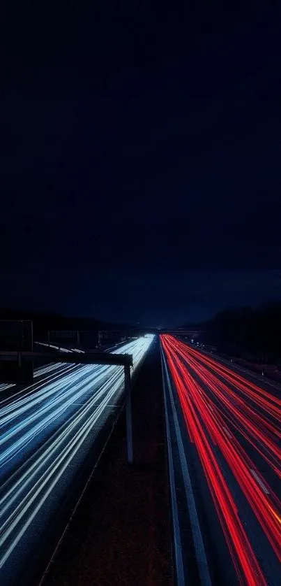 Dark highway with red and blue light trails at night.