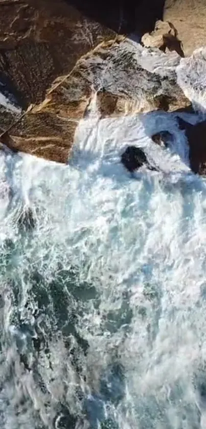 Aerial view of ocean waves crashing over rocky shoreline.