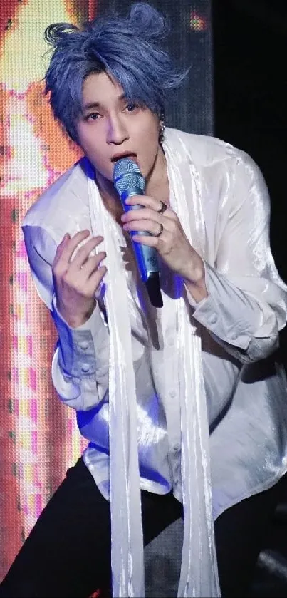 Blue-haired performer singing on stage under bright lights.