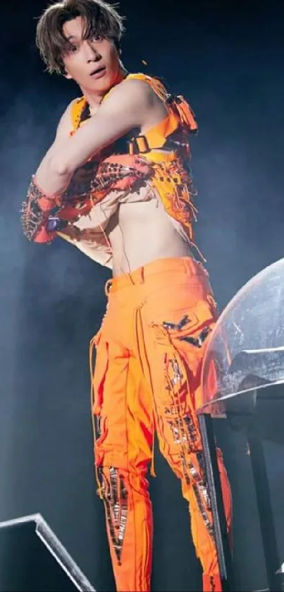 Performer on stage in vibrant orange outfit.